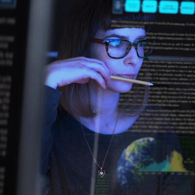 Woman with glasses looking at a digital screen